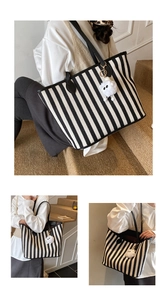 Detail of striped canvas tote bag featuring leather straps and a cute sheep plush charm