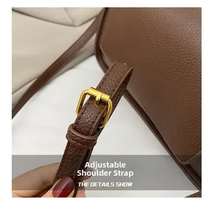 Macro detail of brown litchi pattern leather bag with adjustable golden buckle strap