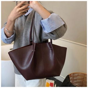 Detailed view of deep wine red matte leather tote bag with elegant wing shape and long straps