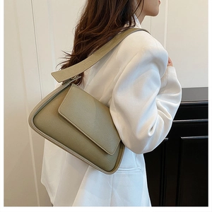 Chic olive green underarm bag with lychee texture leather worn over white blazer