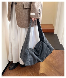 Chic oversized denim tote bag shown styled with a wool blazer and pleated skirt