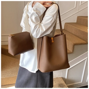 Gros plan du sac seau marron avec motif litchi et mini pochette à fermoir doré