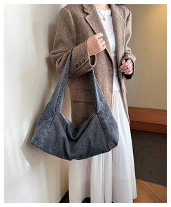 Gray hobo shoulder bag in washed denim material shown on a model in a casual outfit