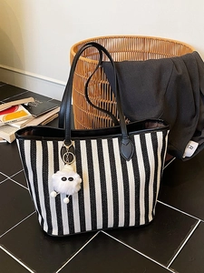 Minimalist black and white striped large tote bag with leather straps and plush charm