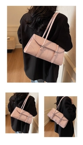 Detail view of pink oil-wax leather baguette bag with dual straps and buckle accents