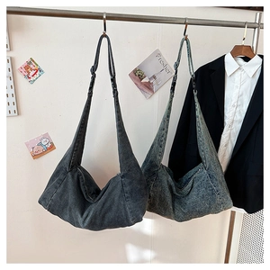 Detail of adjustable shoulder straps with plastic buckles on denim hobo bags