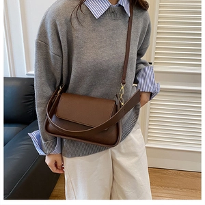 Brown textured leather shoulder bag shown on model for stylish everyday use