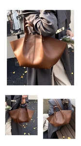 Detailed close-up of dark brown matte leather tote bag with elegant winged design