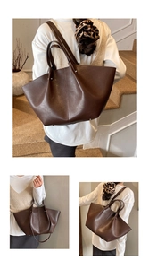 Detailed side view of brown leather wing tote bag with elegant pleats and large capacity