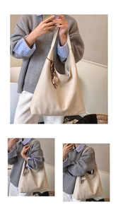 Detail view of large cream hobo tote bag with woven brown tassel and coffee charm