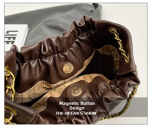 Detail of dark brown quilted chain bucket bag showing magnetic snap closure and lining