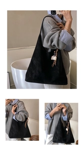 Detail of black suede tote bag with coffee cup charm and woven tassel pendant decoration