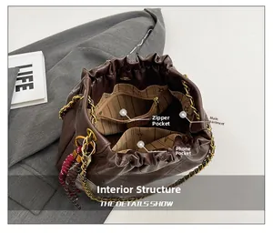 Detailed interior of a brown quilted drawstring bag with chain strap and pockets