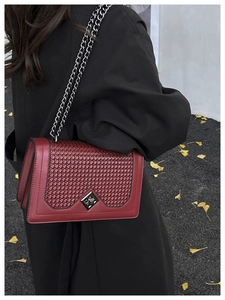 Detail of burgundy chain bag with woven texture flap and silver square lock buckle