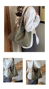 Detail of olive green vintage tote bag featuring a woven tassel and matte leather texture
