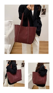 Macro detail of burgundy leopard embossed leather tote bag with silver rivet studs