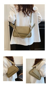 Detail of olive green leather underarm bag with wide strap and gold hardware
