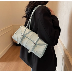 Detail of mint blue oil wax leather baguette bag with silver buckles on shoulder strap