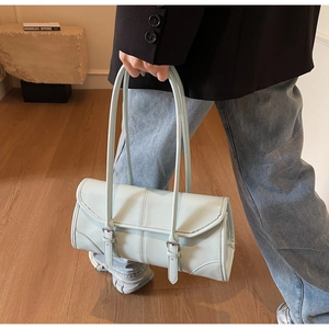 Detail showing mint green oil wax leather texture and vertical stitching on baguette bag
