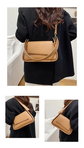 Close-up of litchi pattern leather texture on a khaki crossbody bag with wide strap