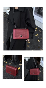 Detail view of red faux leather crossbody bag with woven texture and silver diamond lock