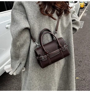 Deep brown lychee grain leather bag with contrast white stitching shown on model