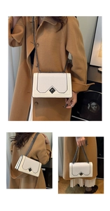 White woven shoulder bag with chain strap and diamond buckle on a camel wool coat