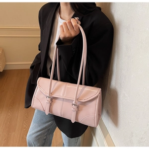 Pink waxed leather baguette bag with dual straps and decorative metal buckles