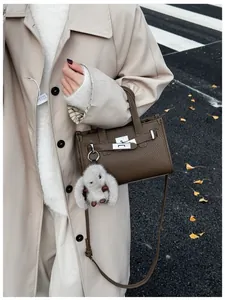 Brown litchi grain leather handbag with silver lock and grey plush rabbit charm