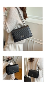 Close-up of black leather shoulder bag featuring woven texture and metallic chain strap