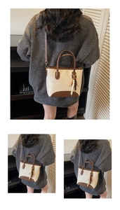 Detail of a retro cream and brown contrast tote bag with a beaded charm and top handle