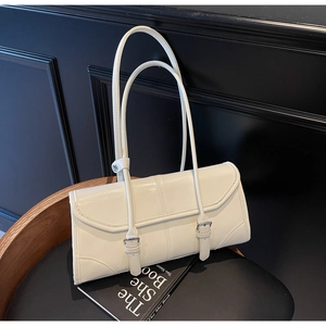 Detail of cream white baguette bag with oil wax finish on a leather seat