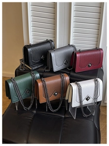 Detail view of woven leather crossbody bags with metal chains in six different colors
