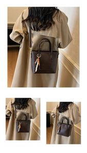 Detailed view of deep brown bucket bag with beaded tassel and adjustable strap