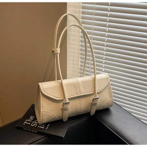 Macro detail of creamy white wax leather underarm bag with silver buckles and flap