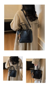 Close-up of retro black shoulder bag with wood bead tassel on stylish trench coat