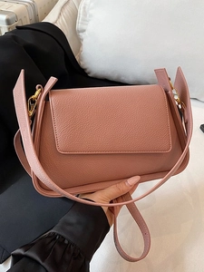 Elegant rose pink lychee leather shoulder bag with gold hardware and flap closure