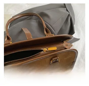 Detail der goldenen Reißverschlüsse an der braunen Wildleder Boston Bag für Damen