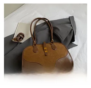 Detail der braunen Wildleder-Boston-Tasche mit Leder-Patchwork und Metall-Verschluss-Schnalle