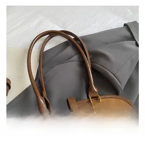 Detail der Vintage-Boston-Tasche aus Wildleder mit braunen Ledergriffen und Goldbeschlag