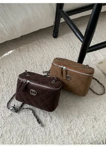 Detailed view of quilted suede vanity bags with leather chain straps in warm autumn tones