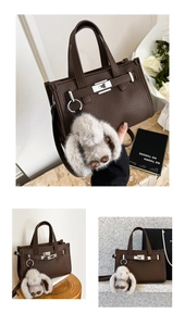 Detail of dark brown lychee texture handbag with silver lock and plush bunny charm