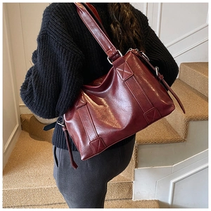 Details der weinroten Vintage-Einkaufstasche mit verstellbarem Riemen und Metallteilen