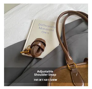 Details des verstellbaren Schultergurts und der Goldbeschläge an der braunen Wildledertasche