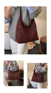 Detail of burgundy large tote bag featuring vintage suede texture and contrast white stitching