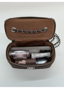 Internal view of brown quilted chain bag showing space for phone and makeup