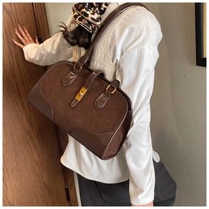 Detail der dunkelbraunen Boston-Tasche aus Wildleder mit Lederbesatz und Goldverschluss