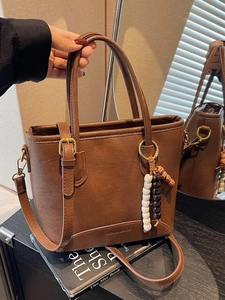 Minimalist brown contrast bucket bag in matte PU leather with beaded charm and strap