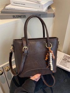 Elegant dark brown bucket bag with top handles and colorful beaded charm detail