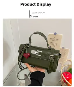 Détail du sac à main vert en cuir avec fermoir argenté et pampille décorative